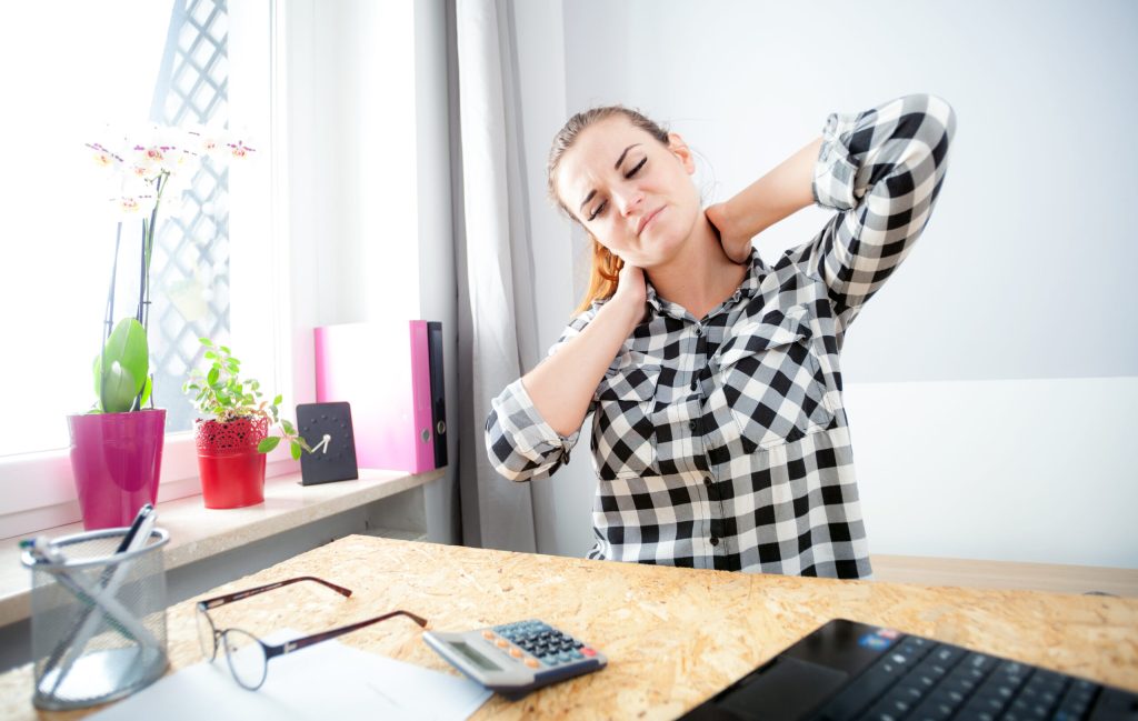 Cervicogenic headache treatment: 4 common methods of pain relief tired woman with neck pain during work in home off DQ9TJ39 scaled 1 cervicogenic headache treatment: 4 methods | back in motion
